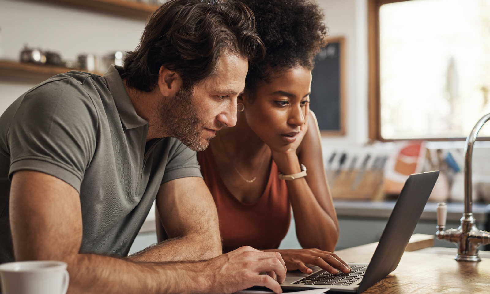 Couple using laptop to manage home electricity.