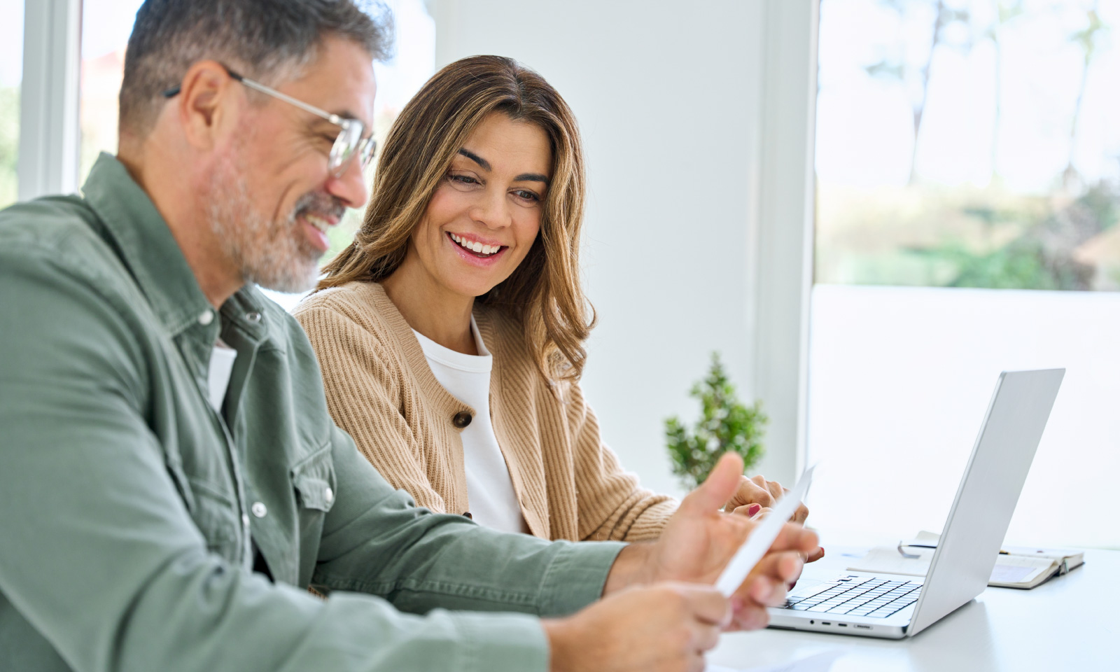 Couple checking prepaid electricity plan on laptop