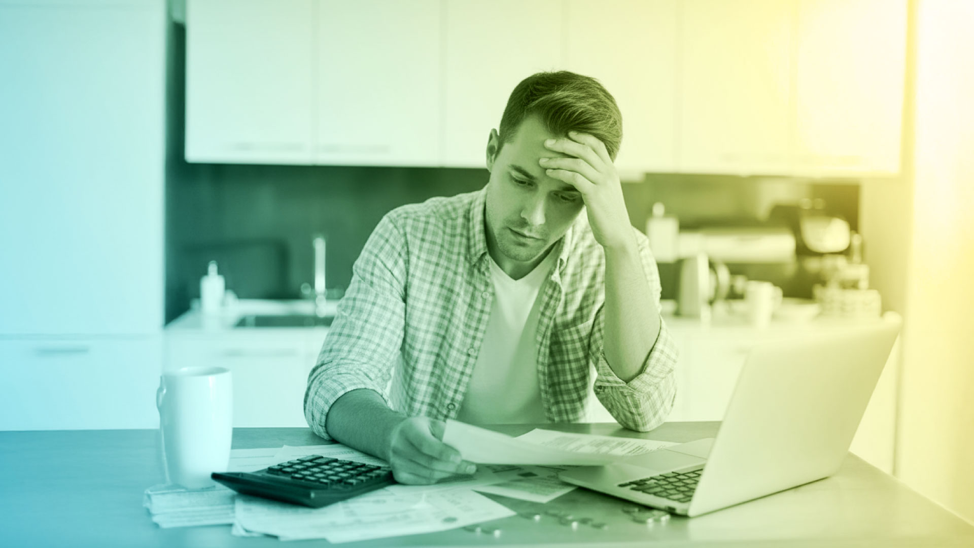 Man looking at an electric bill while on his laptop